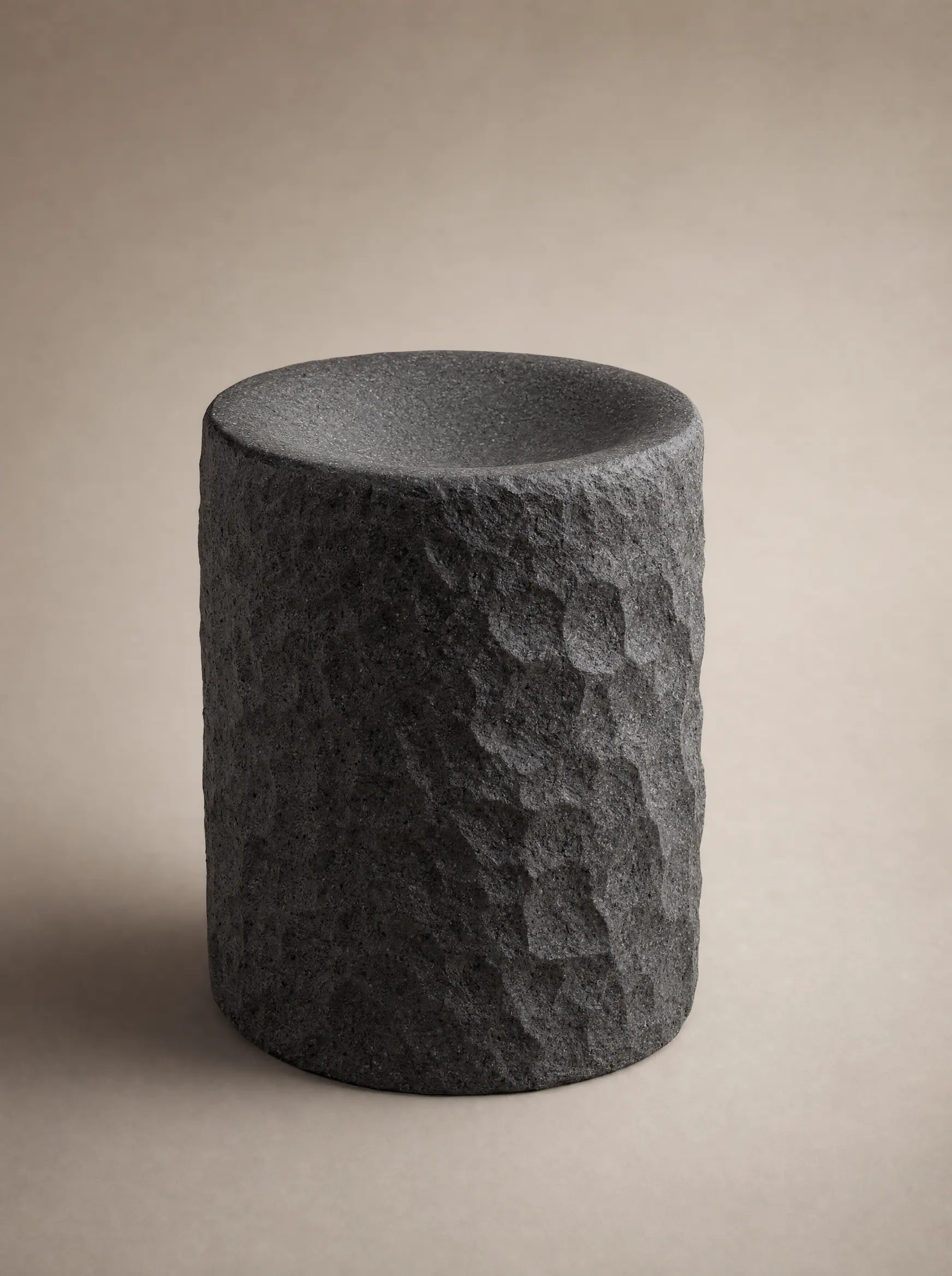 A hewn basalt cylinder with a shallow basin top